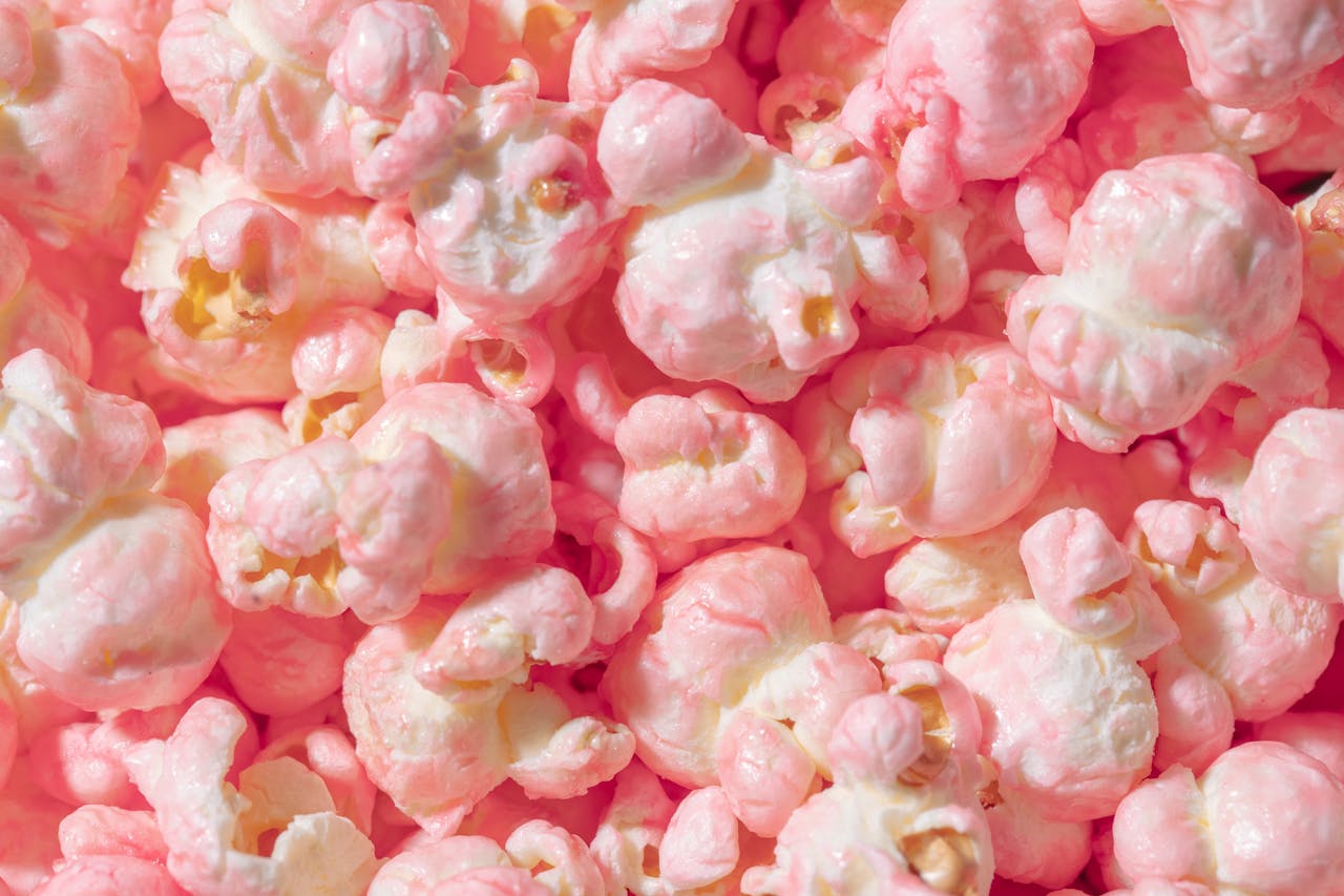 about-us Vibrant close-up of pink candy coated popcorn, perfect for sweet snack themes.